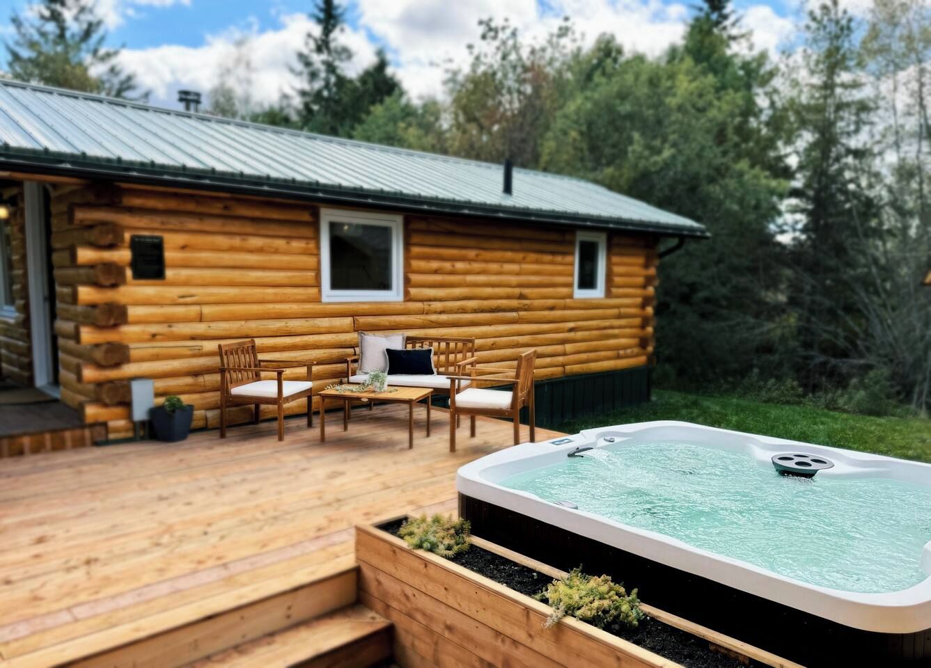 A log cabin with a hot tub and outdoor seating.