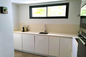 A kitchen with a window, a sink, and a microwave. - Sea View Apartment in La Paloma de Manilva (Manilva)
