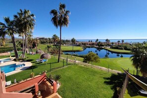 A resort with a swimming pool, a golf course, and a view of the ocean. - Apartment with Sea and Golf Course Views (Casares)