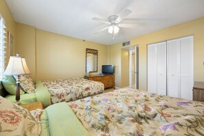 A bedroom with two beds, a ceiling fan, a dresser, a television, and a wardrobe. - Reef Club 509 - Beachfront 3br/2ba luxury condo with pool and tennis (Indian Rocks Beach)