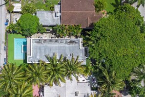 An aerial view of a residential property with a swimming pool, a covered patio, and surrounding greenery. - Ultimate Modern Luxe Getaway | Heated Pool & Spa (Hollywood)