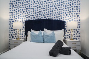 A hotel room with a bed, two bedside tables, and a polka dot wallpaper. - Fort Lauderdale Beach 8BR Modern Retreat (Fort Lauderdale)