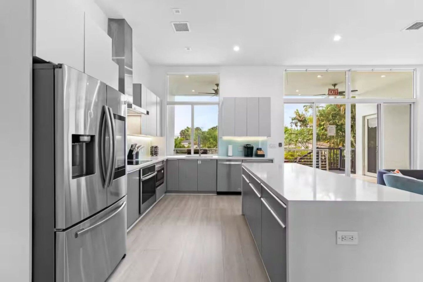 Una cocina moderna con electrodomésticos de acero inoxidable, armarios grises y una isla grande.