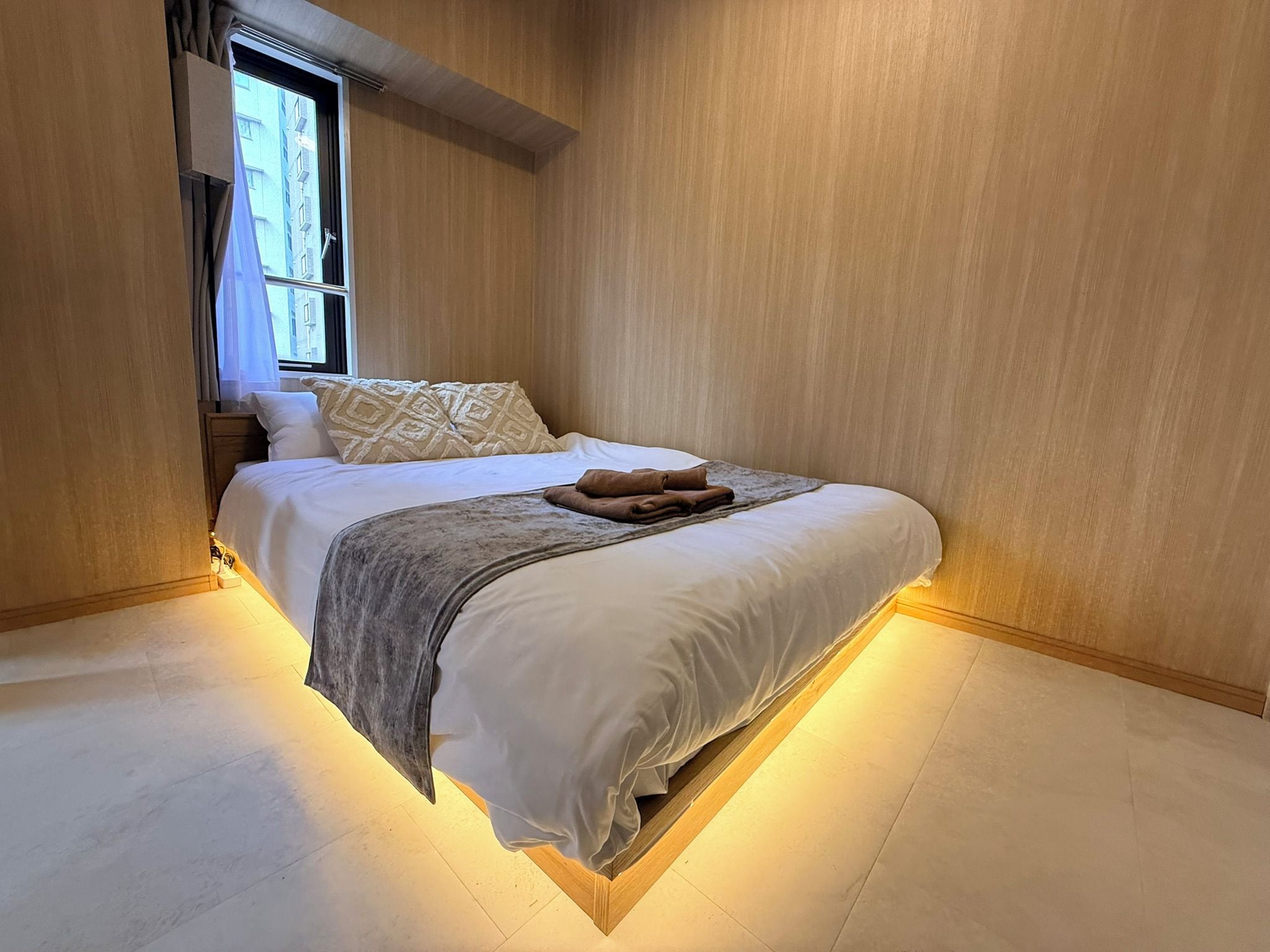 A modern bedroom with a bed, pillows, and a blanket.