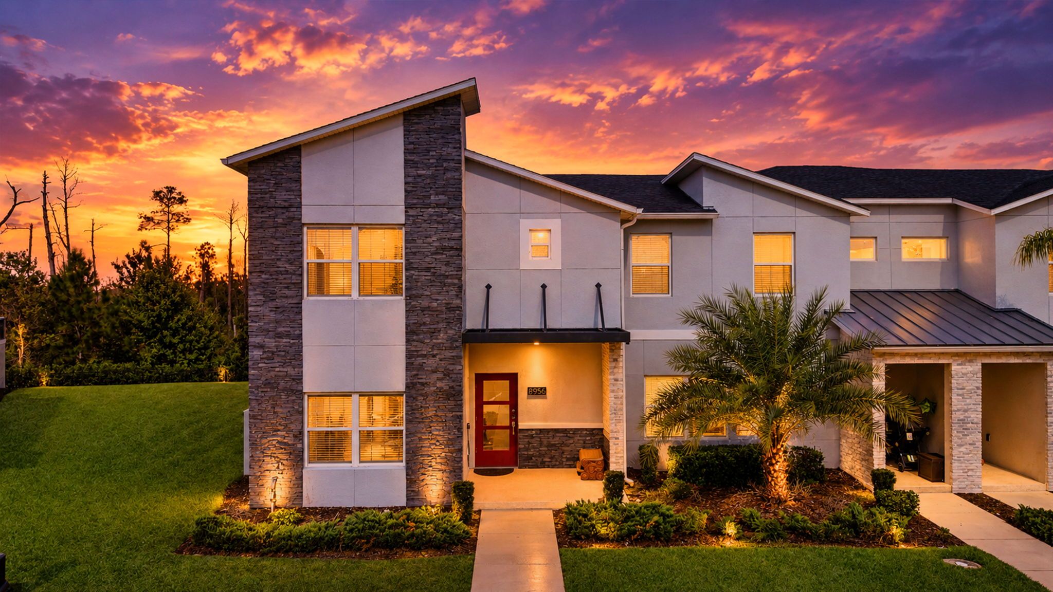 Golden-hour curb appeal shines at this modern Champions Gate villa, with sleek stone accents, lush landscaping, and a warm welcome home.