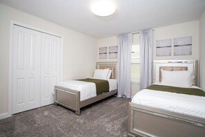 A bedroom with two beds, a door, and a ceiling light. - NEW 5BR Private Pool, Lazy River & Resort 8955 (Kissimmee)
