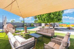 An outdoor patio with a pool, lounge chairs, a table, and a canopy. - PHX | Heated Pool | 10 Min Airport | 18 Scottsdale (Phoenix)