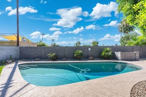 A swimming pool with a clear blue water, surrounded by a concrete deck and a low stone wall. - PHX | Heated Pool | 10 Min Airport | 18 Scottsdale (Phoenix)