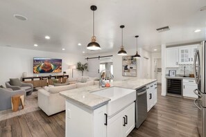 A modern kitchen with a central island, white cabinetry, and stainless steel appliances. - PHX | Heated Pool | 10 Min Airport | 18 Scottsdale (Phoenix)
