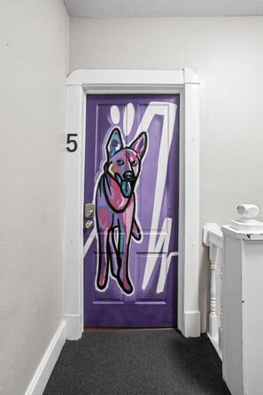 A door with a purple frame and a colorful mural of a dog. - The Dingo - Sunny One Bed Apt, Walk to Mass Ave (Indianapolis)