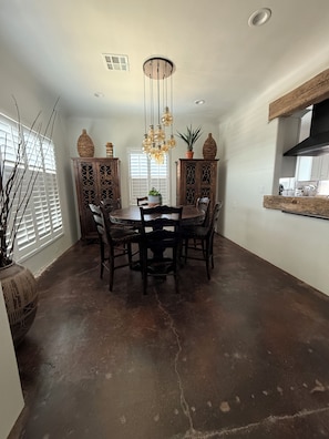 A dining area with a round table, chairs, a chandelier, and decorative cabinets. - Peaceful 3-bedroom house close to Casa Grande, Coolidge, Eloy and Arizona City (Casa Grande)