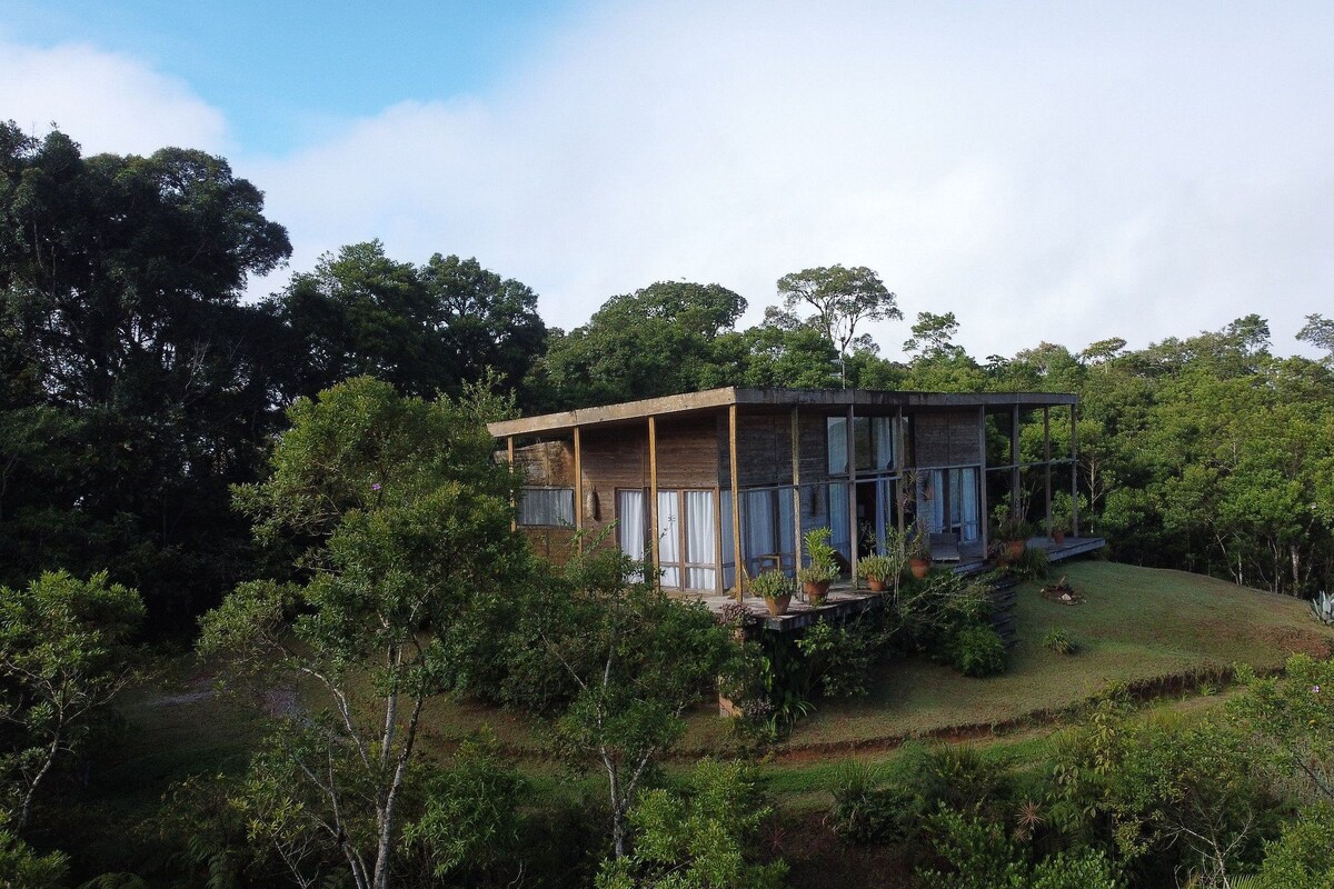 Una casa moderna con techo plano, ventanas amplias y un porche cubierto.