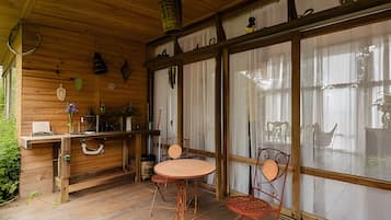 Um interior de madeira com área de bar, uma mesa redonda e duas cadeiras.