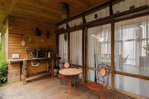 Un interior de madera con una barra, una mesa redonda y dos sillas.
