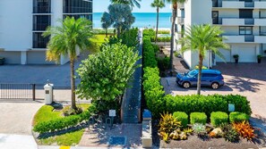 A modern hotel with a pool, palm trees, and a view of the ocean. - Coastal Luxury at Vanderbilt Beach! (Naples)