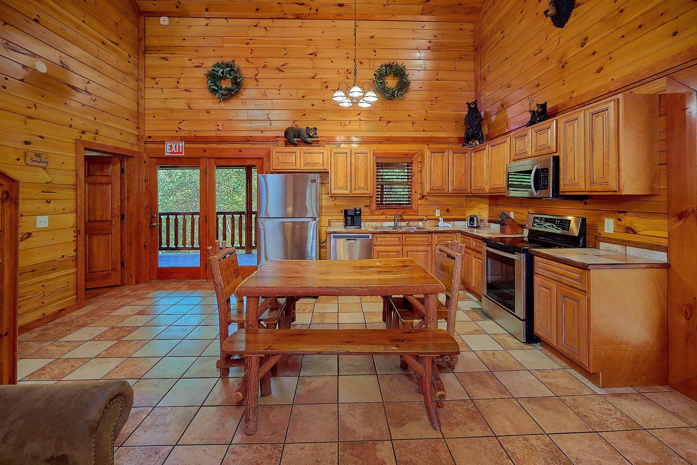 Interno di una cabina con arredamento in legno, un tavolo da pranzo, elettrodomestici e vista attraverso la porta.