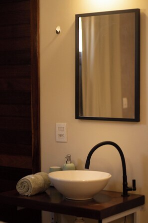 Un baño con un lavamanos blanco, un espejo y una toalla.
