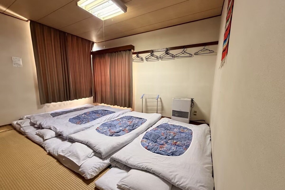 Una habitación de hotel con una cama, un calefactor y un tendedero fijado a la pared.
