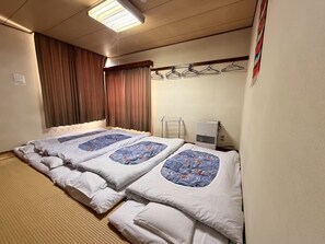 Una habitación de hotel con una cama, un calefactor y un tendedero fijado a la pared.