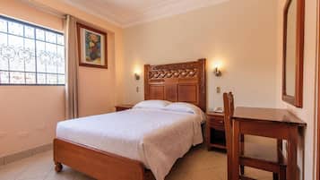 Un dormitorio con una cama de madera, una mesita de noche y una silla.