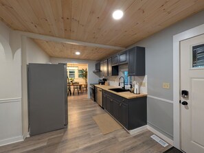 Eine moderne Küche mit dunklen Schränken, einer Holz Arbeitsplatte und einem eingebauten Ofen.