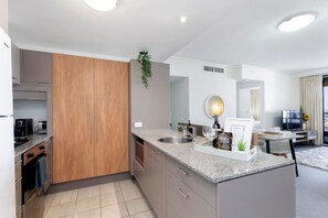A modern kitchen with granite countertops, stainless steel appliances, and a built-in oven. - *Luxe CityScape with River Views* 2b 2ba Sauna Gym (Brisbane City)
