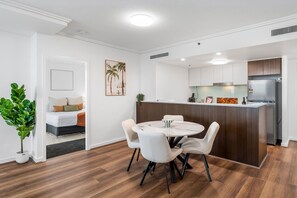 Un intérieur moderne comprenant un espace repas, une cuisine et une chambre.