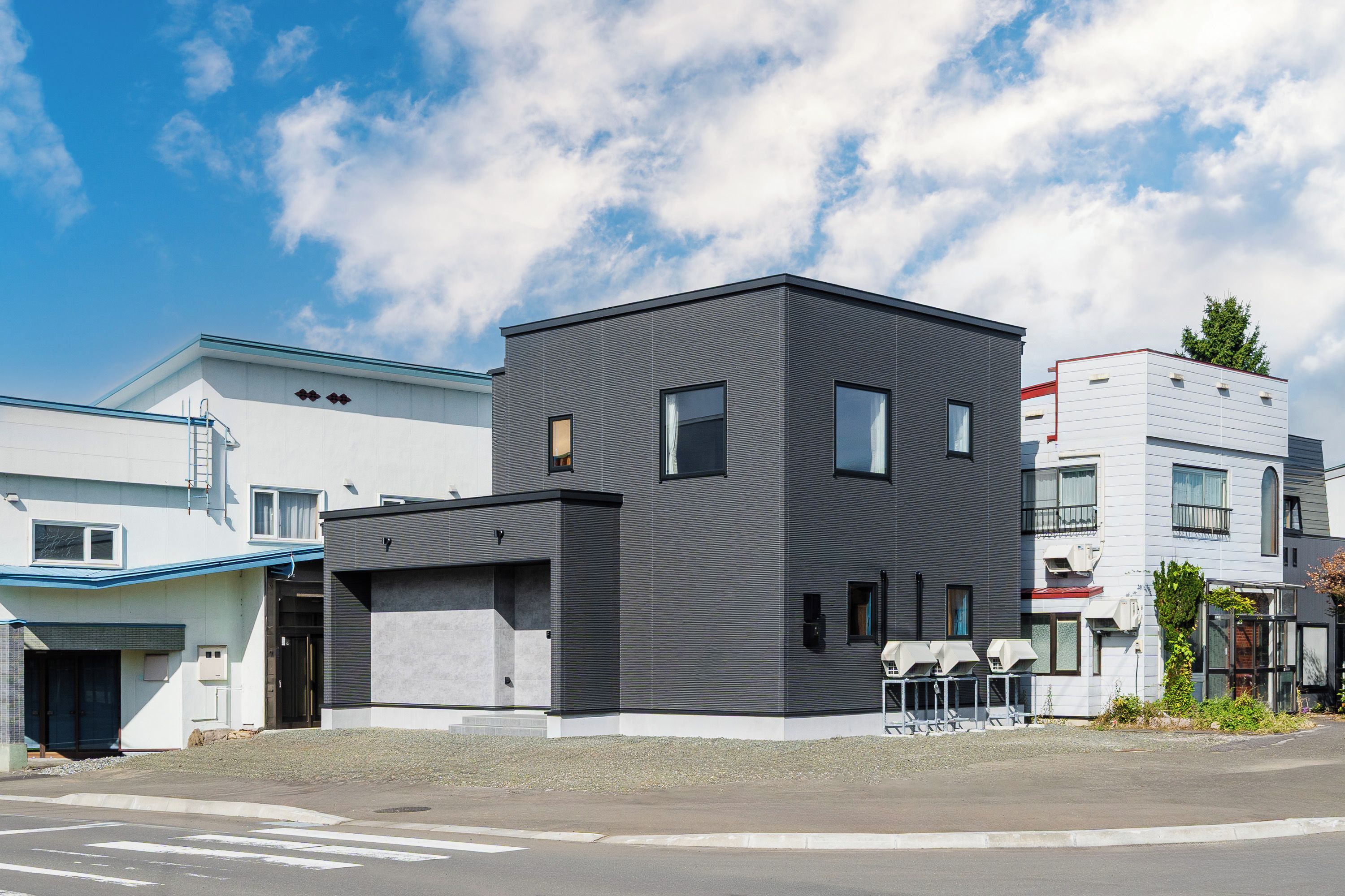 A modern building with a flat roof, rectangular windows, and a flat facade.