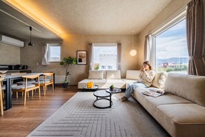 Una sala moderna con un sofá, una mesa de centro y una zona de comedor.