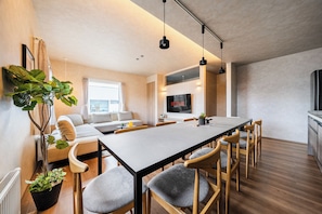 A modern interior with a dining area, sofa, and a large plant. - Furanest (Sorachi-gun)