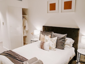 A bedroom with a large bed, bedside tables, a wardrobe, and framed pictures on the wall. - Lavish Highend Skytower 2B/2B City Apt. Carpark (Brisbane City)