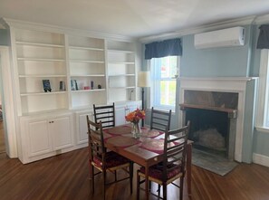 A dining room with a wooden table, chairs, and a fireplace. - Historical 5-bed brick home with modern amenities (Hinsdale)
