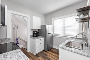 A kitchen with a refrigerator, coffee maker, and a sink. - Earthy Escape - 5 min to downtown (Indianapolis)