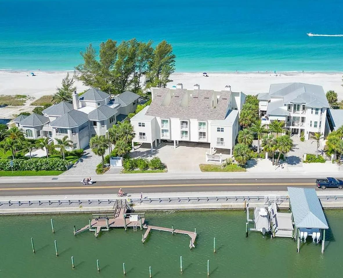 A coastal property with multiple buildings, a marina, and a beach.