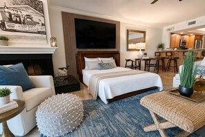 A hotel room with a large bed, a television, a dining area, and a fireplace. - Beachfront View Condo Getaway 2bd2ba Indian Shores (Indian Shores,)