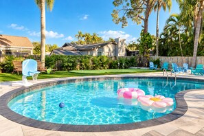 A swimming pool with a curved edge, surrounded by a wooden deck. - Clearwater Fun House, Games, Heated Pool, Hot Tub Sleeps12 (Clearwater)