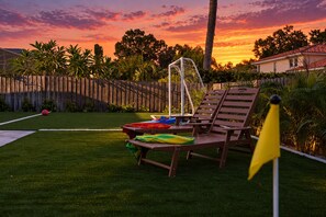 A backyard with a swing set, a small pool, and lounge chairs. - Clearwater Fun House, Games, Heated Pool, Hot Tub Sleeps12 (Clearwater)
