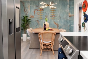 A modern kitchen with a marble backsplash, a central island with seating, a built-in stove, and a wall-mounted wine rack. - Clearwater Fun House, Games, Heated Pool, Hot Tub Sleeps12 (Clearwater)