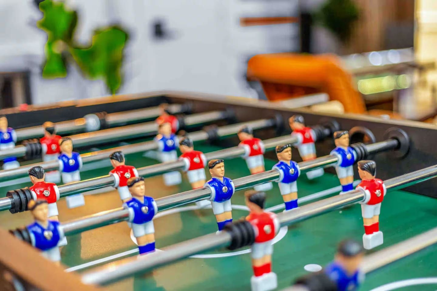 A foosball table with player figures in red and blue uniforms.