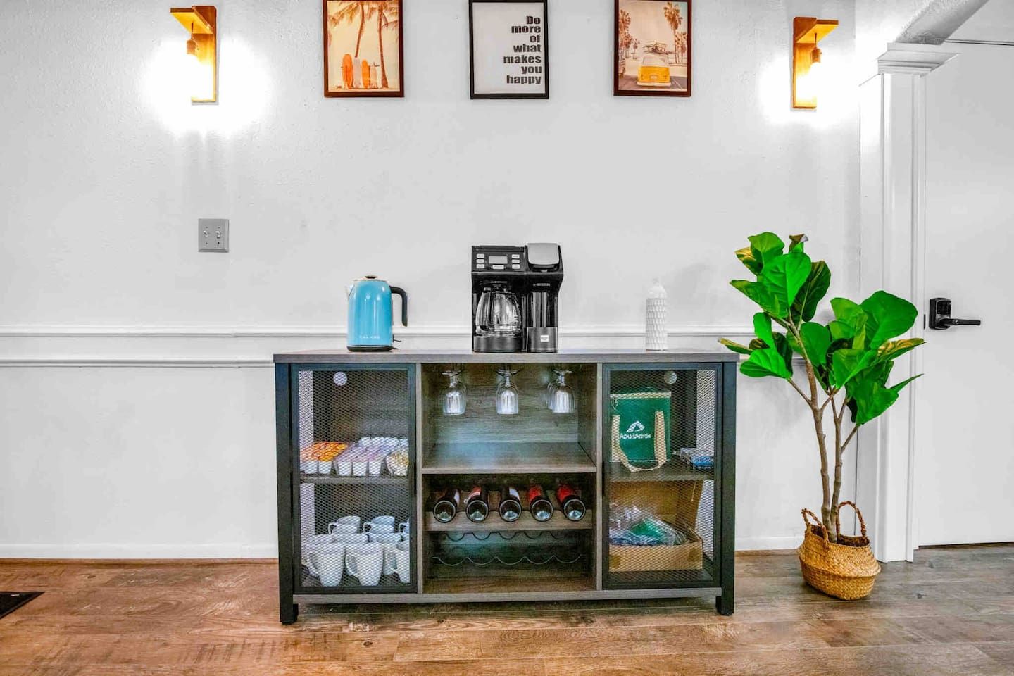 A kitchenette area with a coffee maker, a kettle, and a cabinet with storage shelves.
