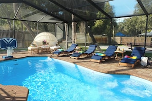 A swimming pool with lounge chairs and a covered area. - TPA Fun Compound by Airport / Restaurants (Tampa)