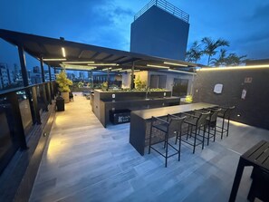 An outdoor bar area with seating and a view of the cityscape. - New Listing (João Pessoa)
