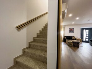 A staircase leading to a living area with a sofa and a coffee table. - House Sleeps 4 with Parking and Balcony (viseo)