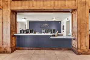 A reception desk with a dark blue backdrop, wooden paneling on the walls, and a sign that reads 'SILVERADO'. - Silverado 106 | Walk to Lifts | Pool | Hot Tub | Fireplace | Sleeps 4 (Park City)