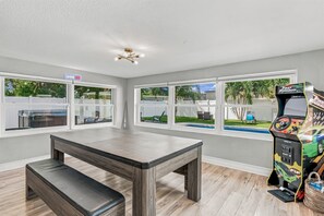 A room with a pool, a gaming console, and a bench. - 🌴Palm Breeze Retreat- Home with a pool, hot tub & game room near Clearwater Beach! (Largo)