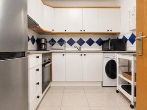 A compact kitchen with white cabinets, a stainless steel refrigerator, a microwave, a washing machine, and a coffee maker. - EXCELLENT SITUATION IN FRONT OF THE CITADEL, ON THE OUTSKIRTS OF THE TOWN. 20m FROM THE SEAFRONT AND TO THE BEACH. (Roses)