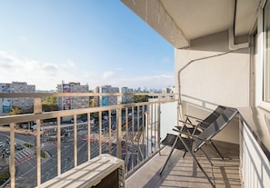 Ein Balkon mit Blick auf eine Stadtansicht, einschließlich Gebäude und einer Straße.