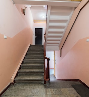 Eine Treppe mit Handlauf führt zu einer Tür.