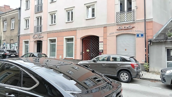 A street view with parked cars and a building with a sign reading 'E & Bella'.