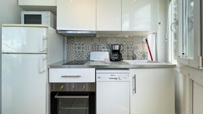 A compact kitchen with a microwave, toaster, coffee maker, and a dishwasher. - Nueva Suecia 716 Studio (San Agustin)